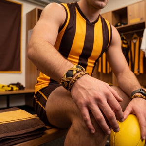 Dark brown and gold bracelet on a wooden surface with text about craftsmanship and style.Handmade leather bracelet with jute weave on a beach setting, featuring text about product features. footy,HAWTHORN HAWKS,football,club,AFL,
#AFL #Footy #AustralianRulesFootball #AFLBracelets #HandmadeJewelry #FootyFans