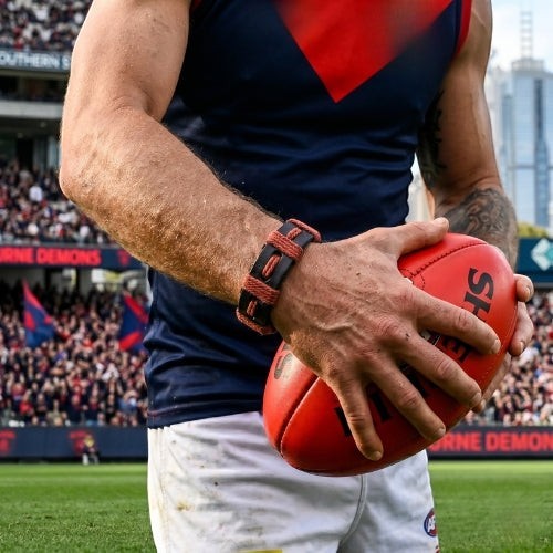 KANDM PARSE LEATHER SHOP navy blue and burgundy braided leather bracelet worn by a fan at an Aussie rules football game