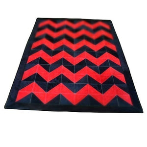 KANDM PARSE LEATHER SHOP handcrafted patchwork rug in black and red cowhide with a geometric chevron pattern.