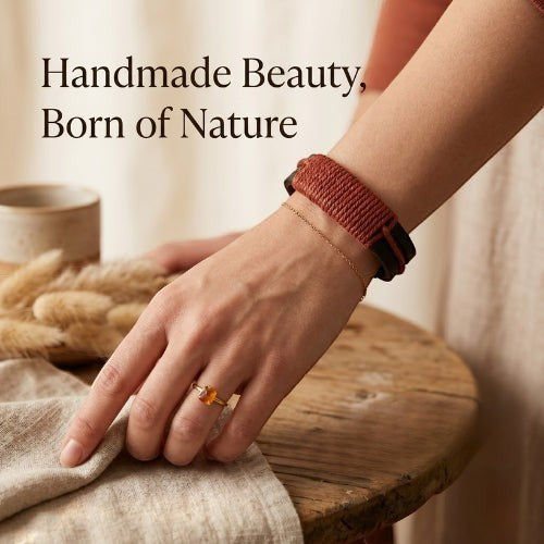 KANDM PARSE LEATHER SHOP handcrafted black leather bracelet with a red-brown woven cord wrap on a woman's wrist.